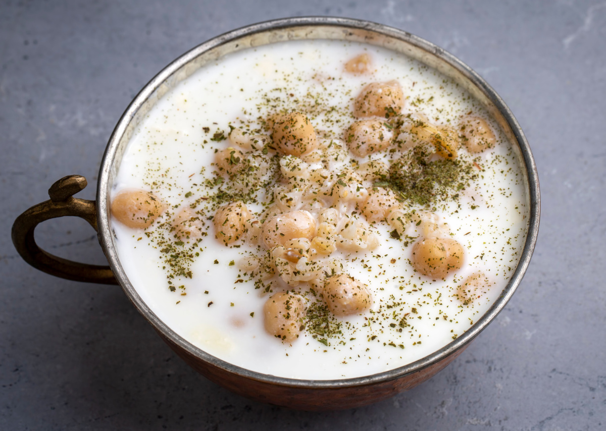 Soupe froide turque (Ayran Aşı) au yaourt et pois chiches, servie dans un bol en m&eacute;tal.