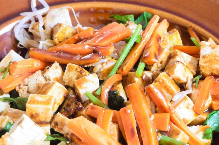 Tofu sauté aux légumes avec une sauce brune.
