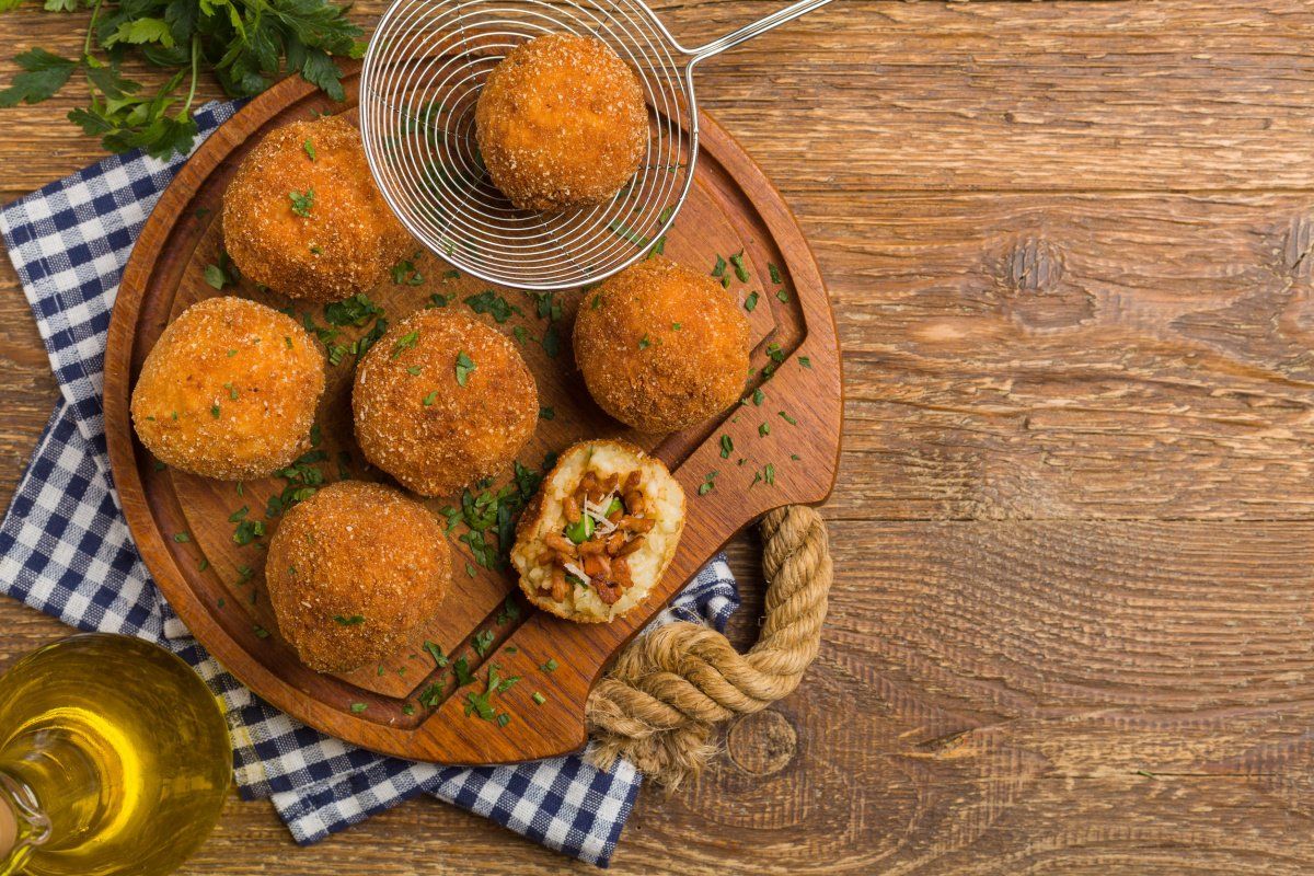 Boulettes de riz frites farcies &agrave; la sauce tomate et viande, pan&eacute;es et frites.