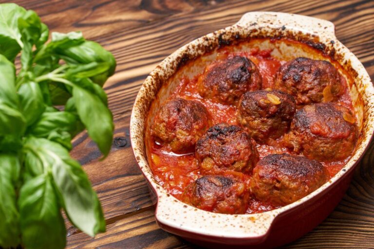 Plat de boulettes de viande gratinées à la sauce tomate.