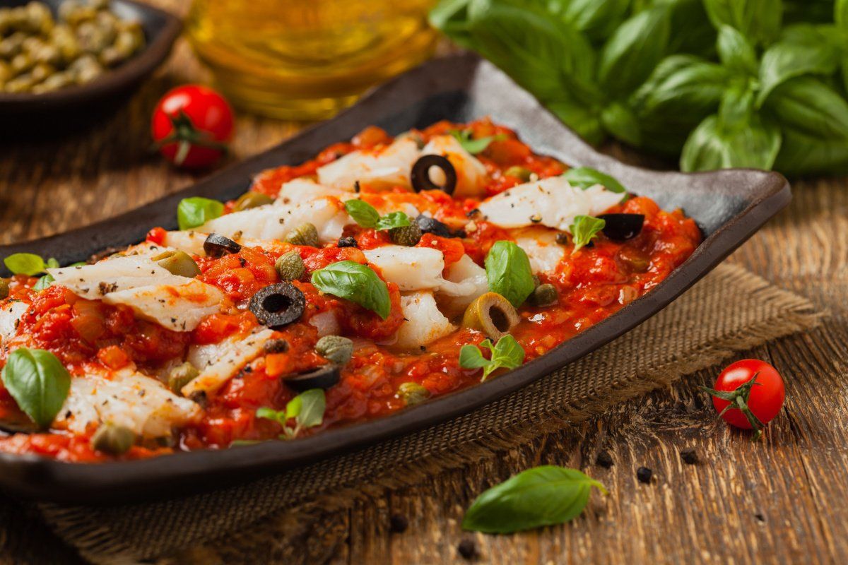 Filets de cabillaud en sauce tomate avec olives, c&acirc;pres et basilic frais.