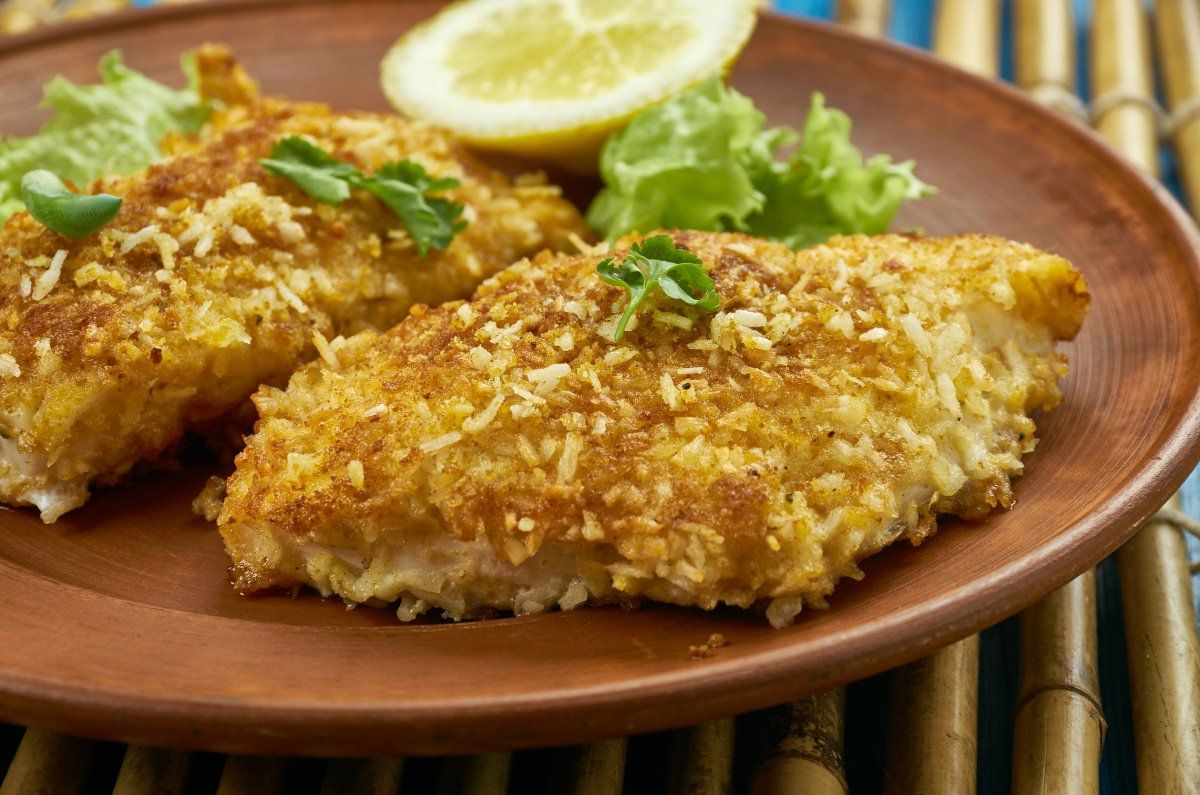 Filets de cabillaud dor&eacute;s en cro&ucirc;te de noix de coco, servis avec du citron.