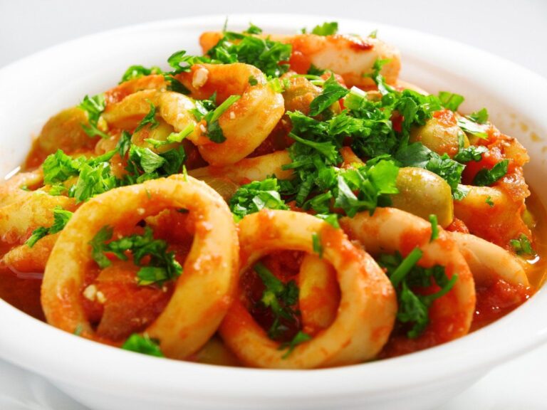 Calamars en sauce tomate avec des olives vertes et du persil frais.