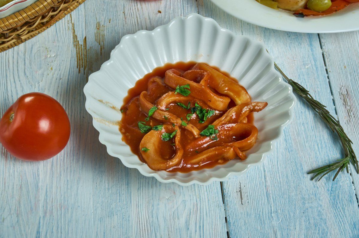 Calamars mijot&eacute;s dans une sauce tomate et garnis de persil frais.