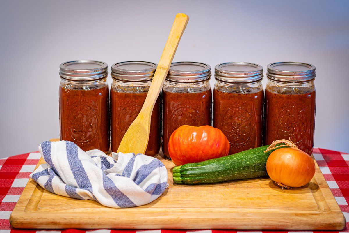 Bocaux de sauce tomate maison avec des l&eacute;gumes frais.