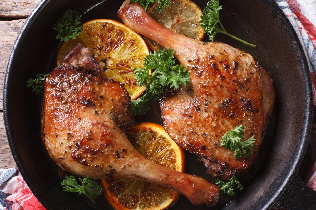 Cuisses de canard r&ocirc;ties &agrave; l'orange, garnies de persil frais.