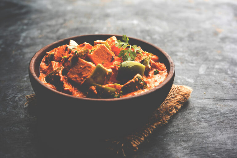 Curry rouge de paneer indien avec des poivrons verts et de la coriandre.