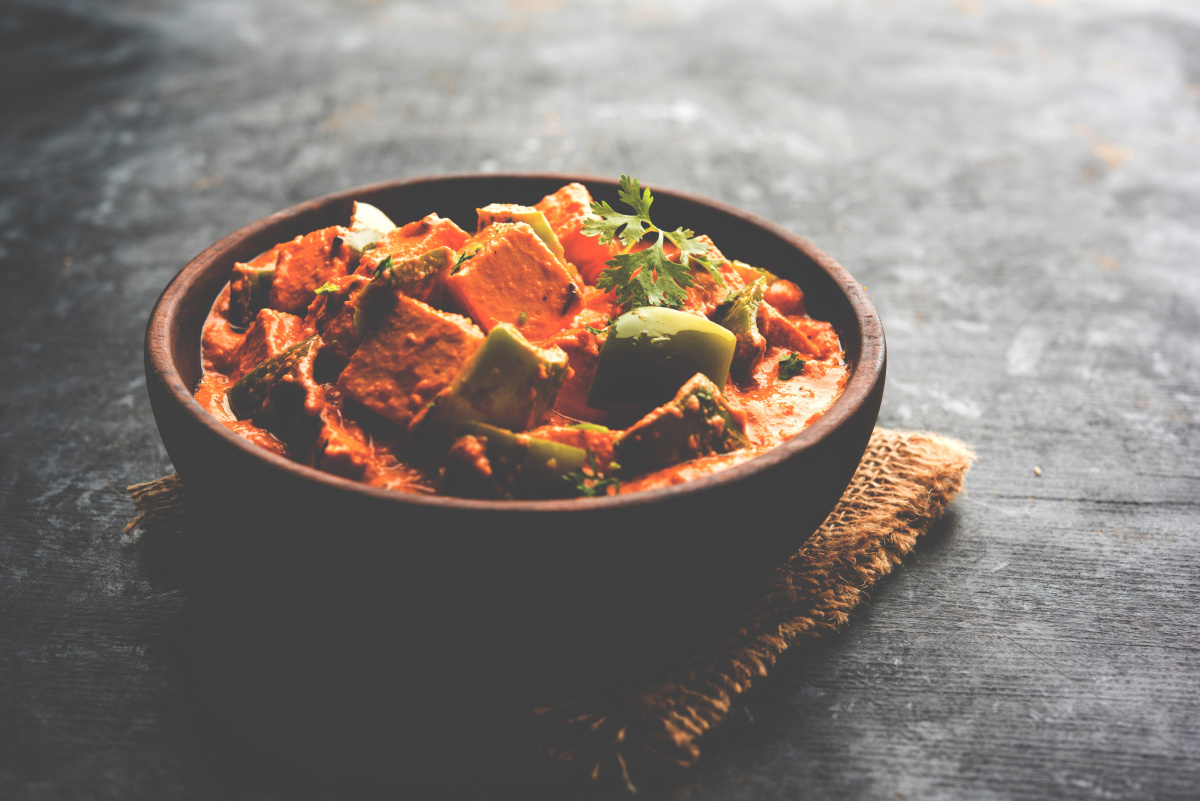 Curry rouge de paneer indien avec des poivrons verts et de la coriandre.