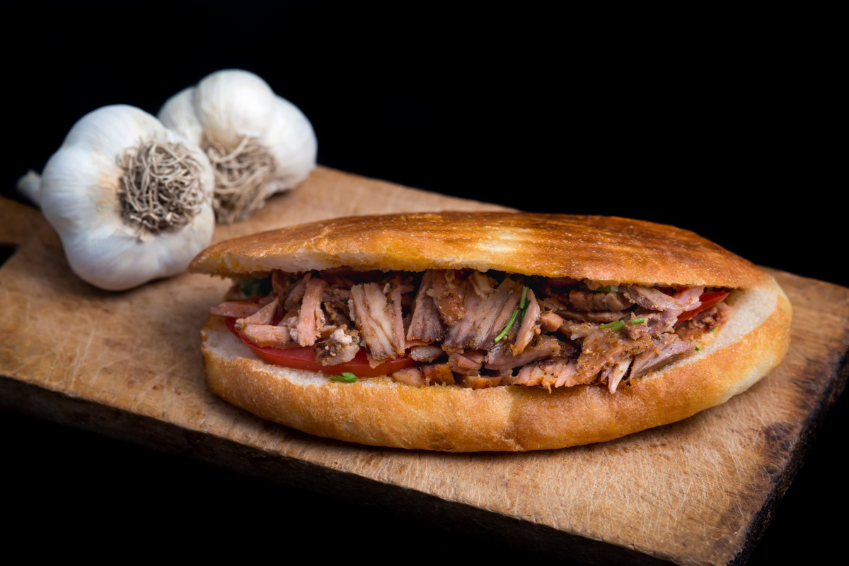 Sandwich d&ouml;ner kebab garni de viande d'agneau grill&eacute;e, de tomates et d'herbes fra&icirc;ches.