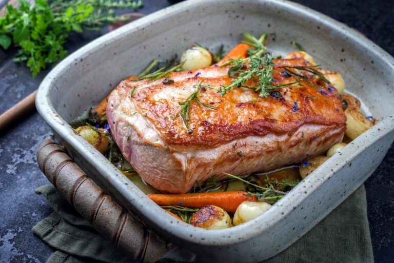 Filet de veau rôti aux herbes, carottes et oignons sortant du four..