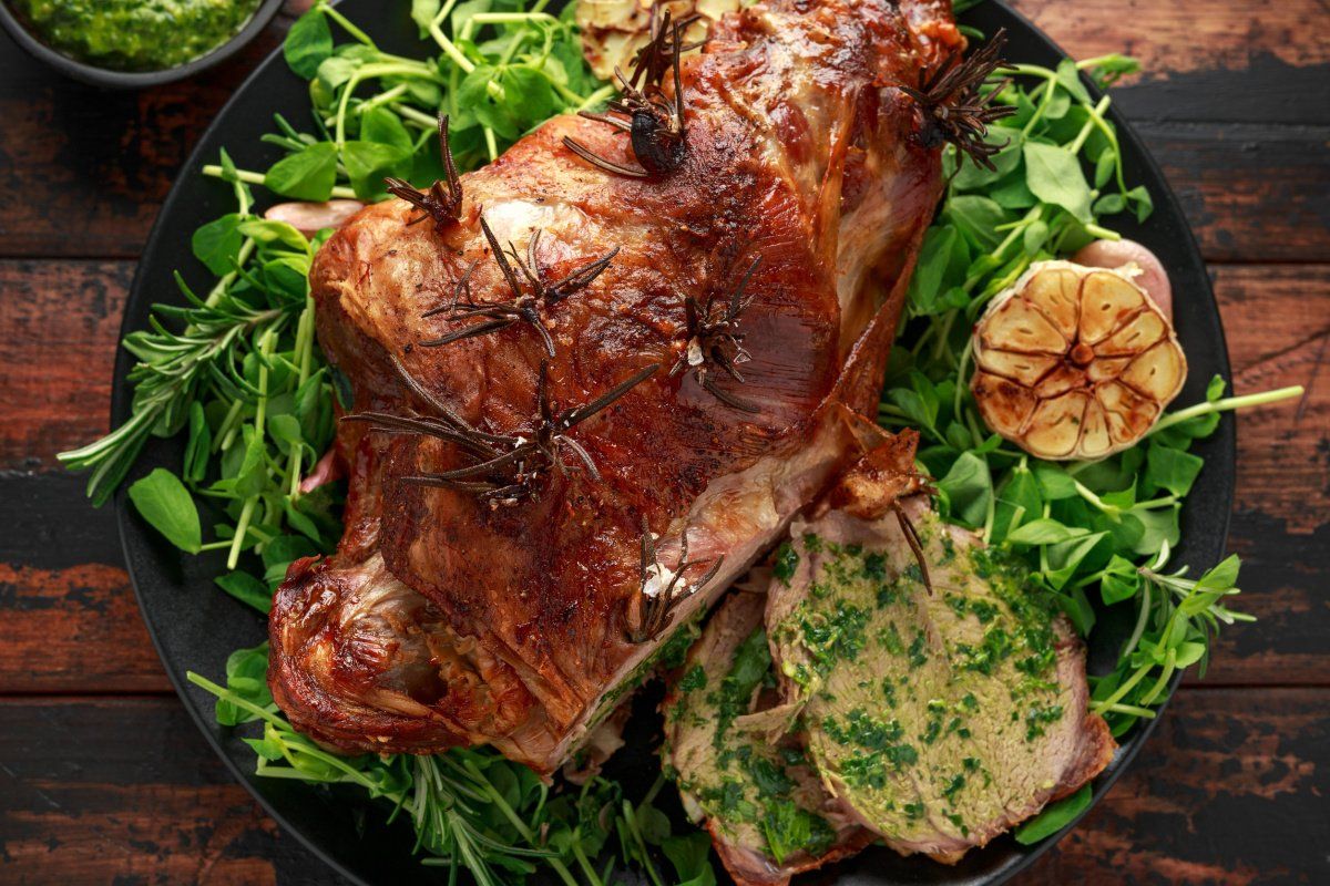 Gigot d'agneau r&ocirc;ti au romarin et &agrave; l'ail, servi avec sa sauce &agrave; la menthe.