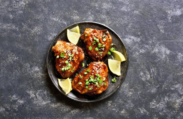Haut de cuisses de poulet grillées et laquées au miel, garnies de sésame et ciboule.
