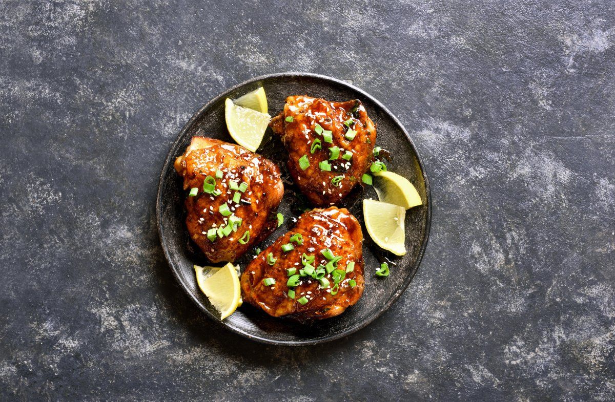 Haut de cuisses de poulet grill&eacute;es et laqu&eacute;es au miel, garnies de s&eacute;same et ciboule.