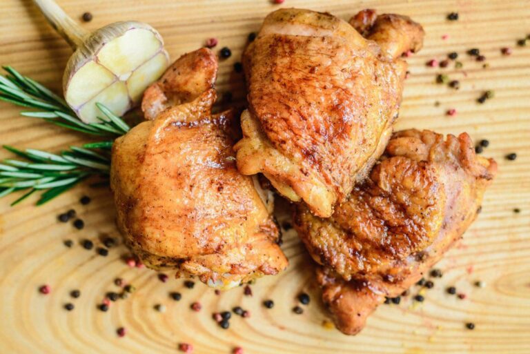 Hauts de cuisses de poulet frits dorés avec ail, romarin et grains de poivre.