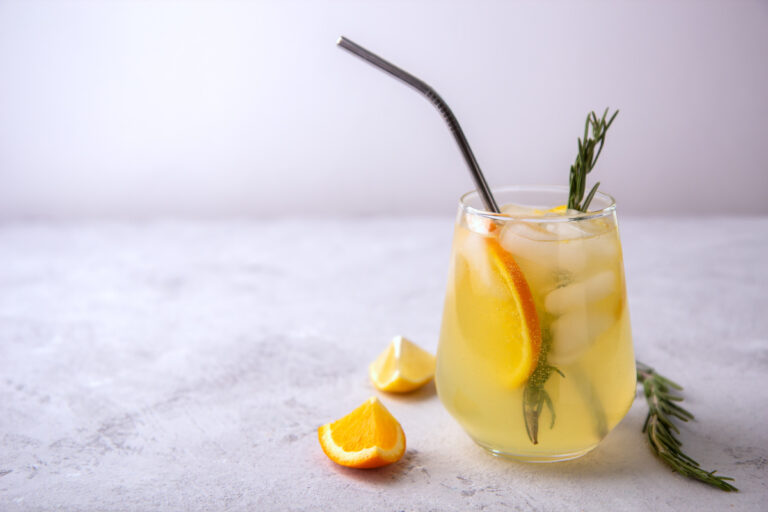 Limonade à l'orange et au romarin servie avec des glaçons.