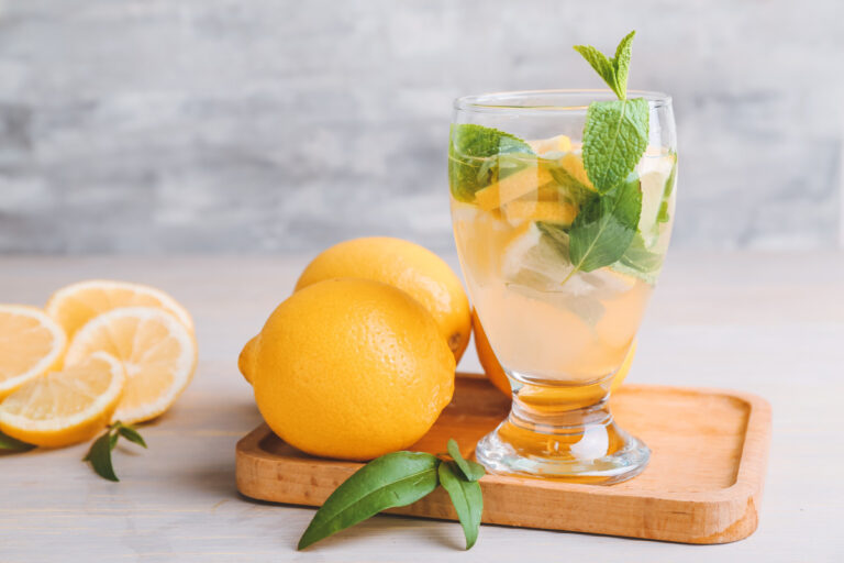 Verre de limonade fraîche avec citrons et feuilles de menthe.