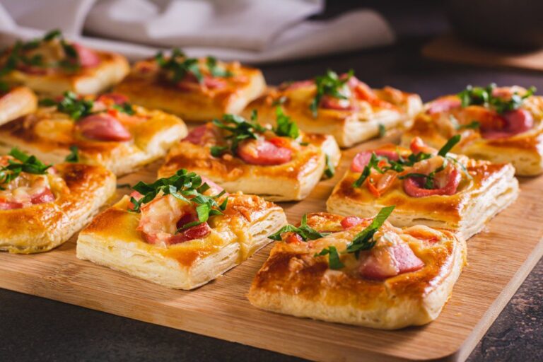 Mini-pizzas carrées aux saucisses, fromage et basilic.