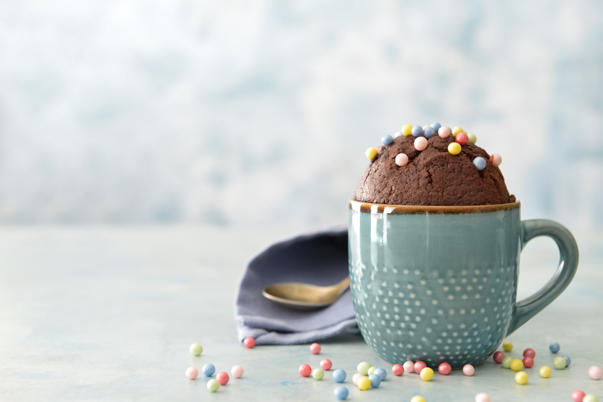 Mug cake au chocolat d&eacute;cor&eacute; de billes color&eacute;es dans une tasse..