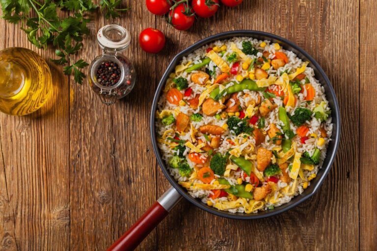 Nasi goreng, un plat de riz frit avec du poulet, de l'œuf et des légumes variés.