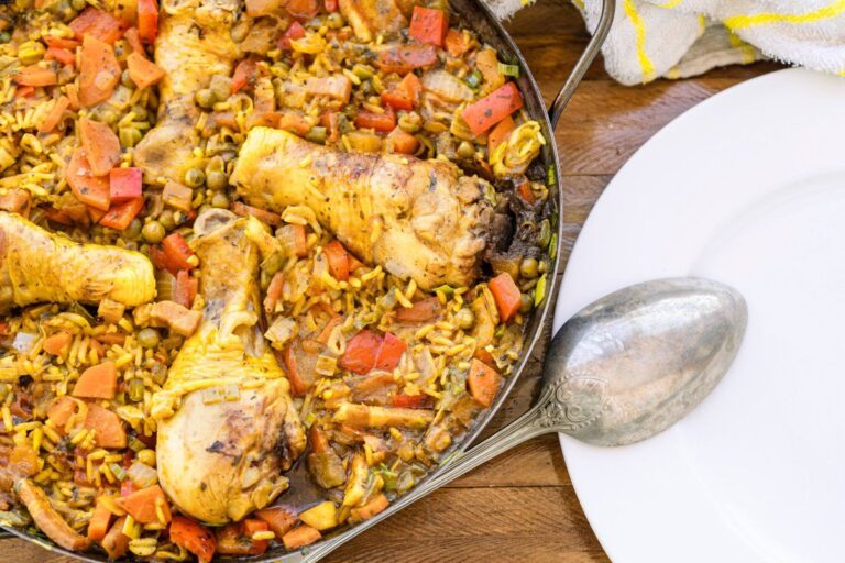 Paella espagnole au poulet, riz safrané et légumes colorés.