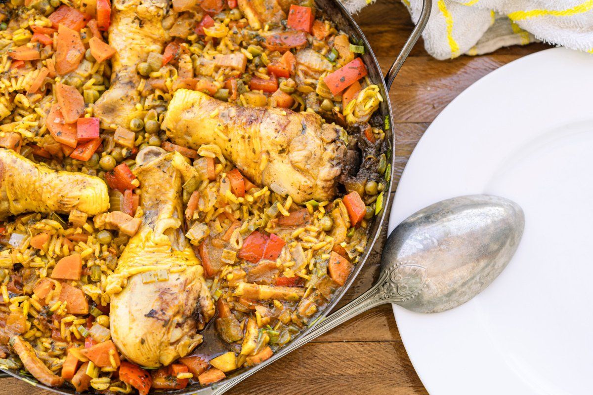 Paella espagnole au poulet, riz safran&eacute; et l&eacute;gumes color&eacute;s.