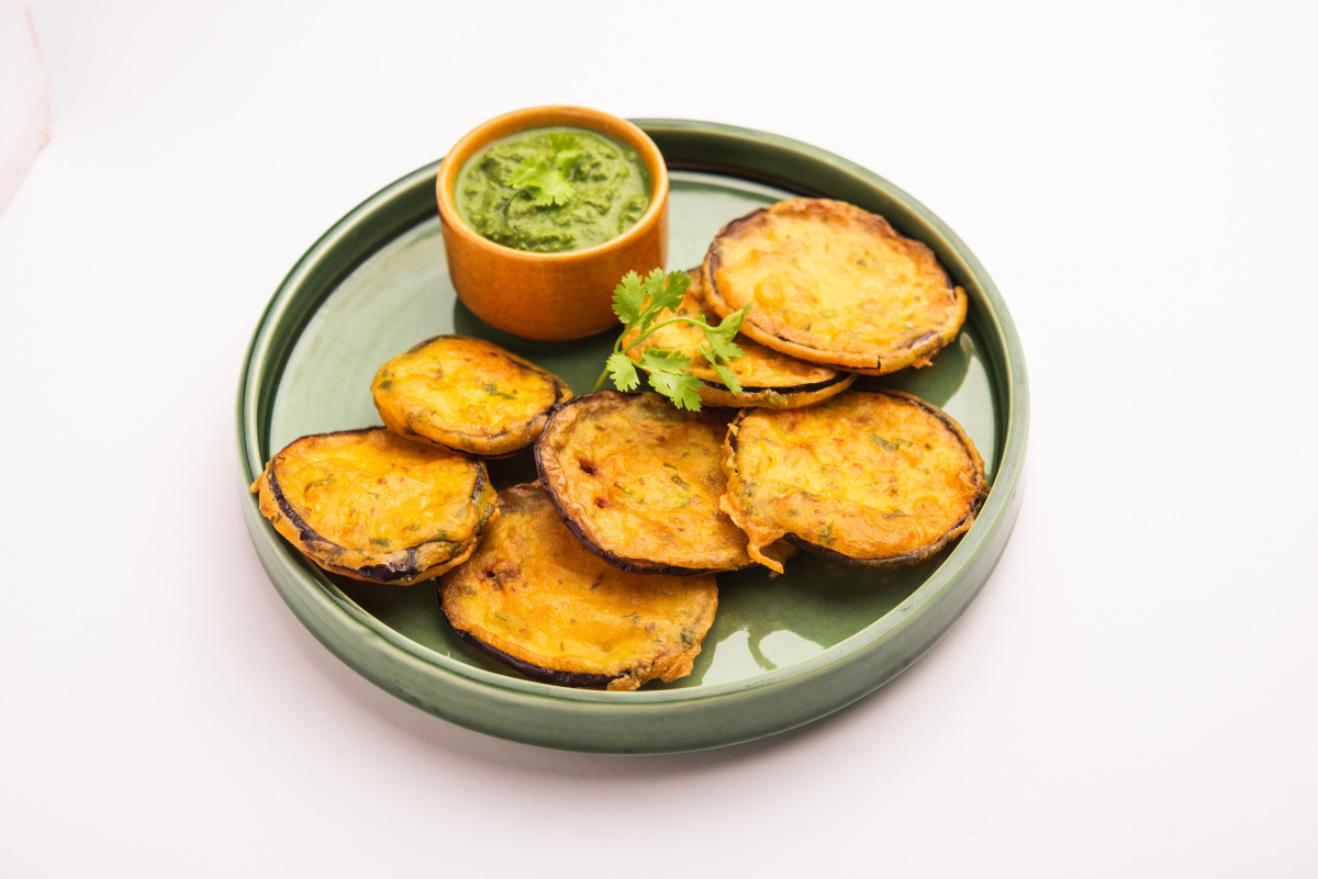 Pakoras d'aubergine, beignets indiens, servis avec une sauce chutney verte.