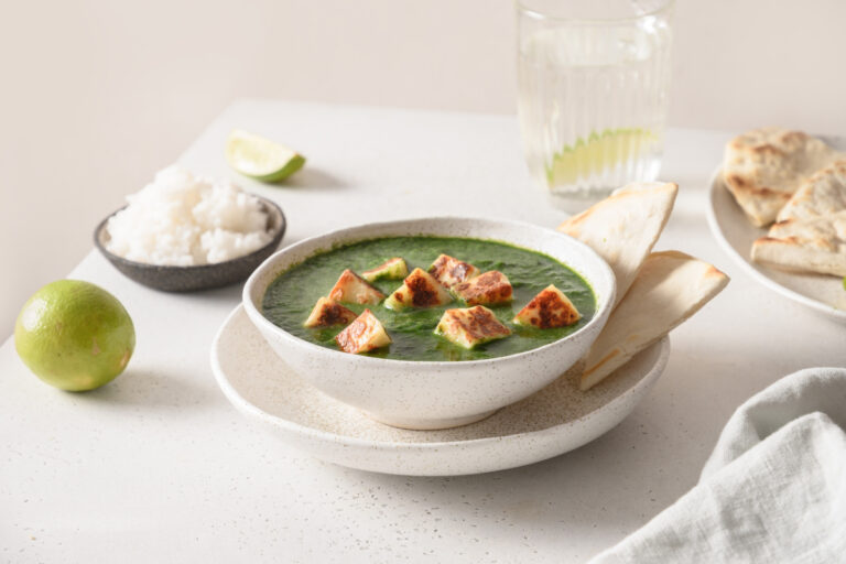 Palak paneer, curry d'épinards au fromage indien, servi avec du riz et des naans.