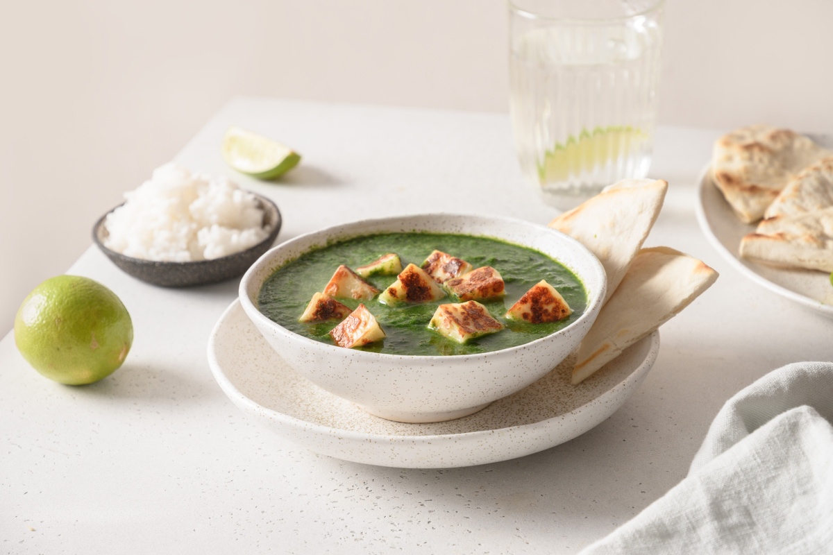 Palak paneer, curry d'&eacute;pinards au fromage indien, servi avec du riz et des naans.