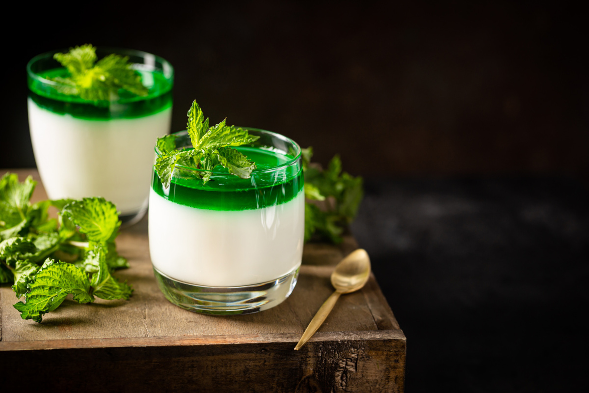 Panna cotta bicolore avec une gelée et des feuilles de menthe fraîche.