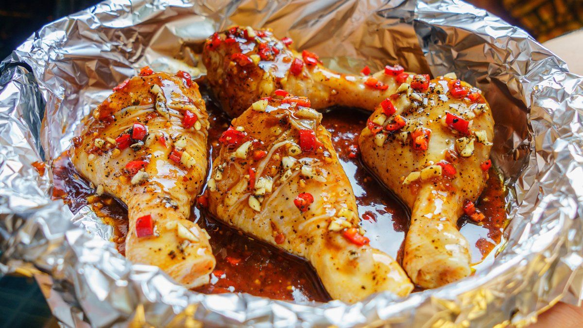 Pilons de poulet crus marin&eacute;s &agrave; l'ail et au piment rouge, pr&ecirc;ts &agrave; cuire.