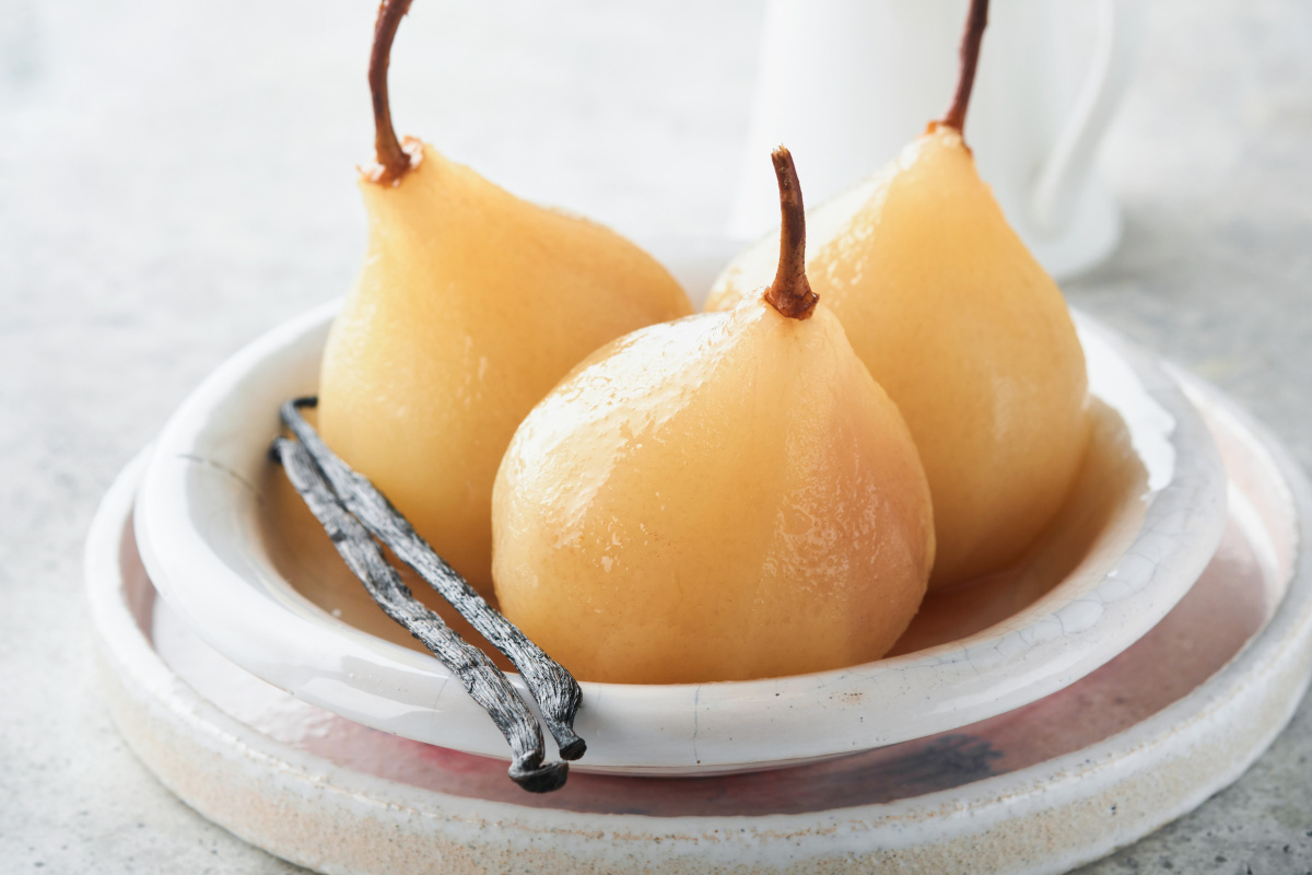 Trois poires poch&eacute;es enti&egrave;res avec des gousses de vanille.