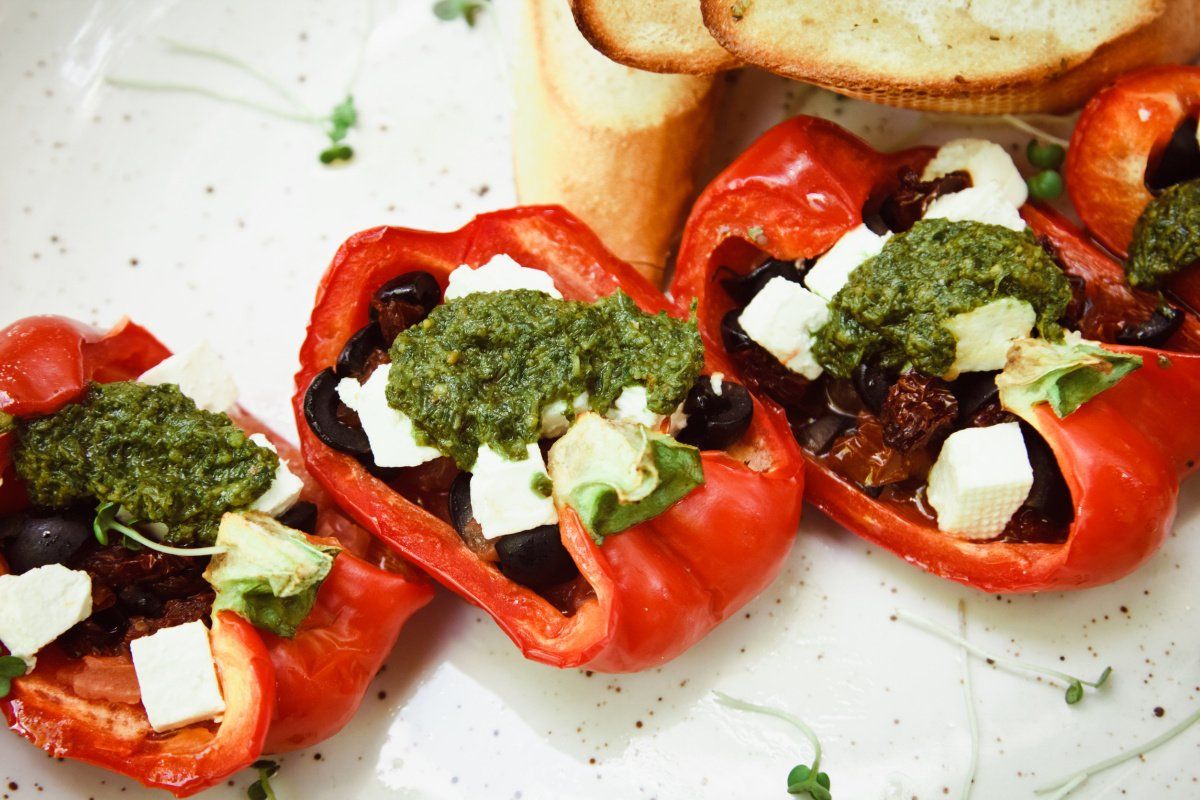 Poivrons rouges r&ocirc;tis farcis &agrave; la mozzarella, olives noires et pesto.