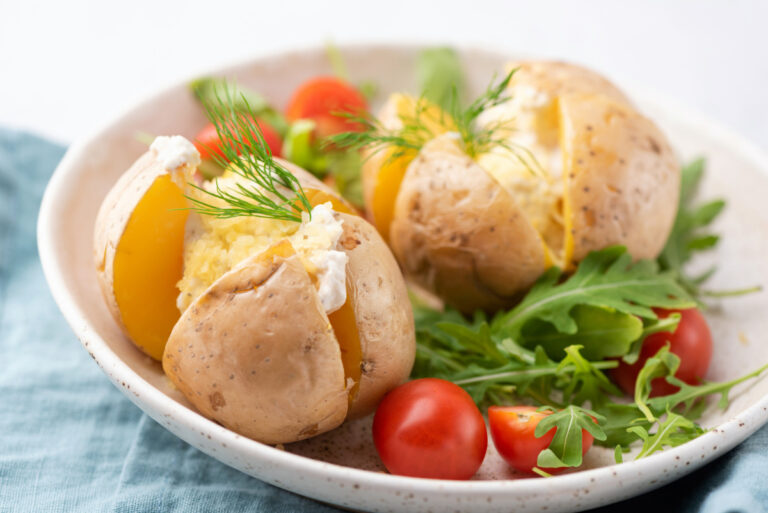Pommes de terre au four garnies de crème, fromage et aneth, avec salade de roquette.