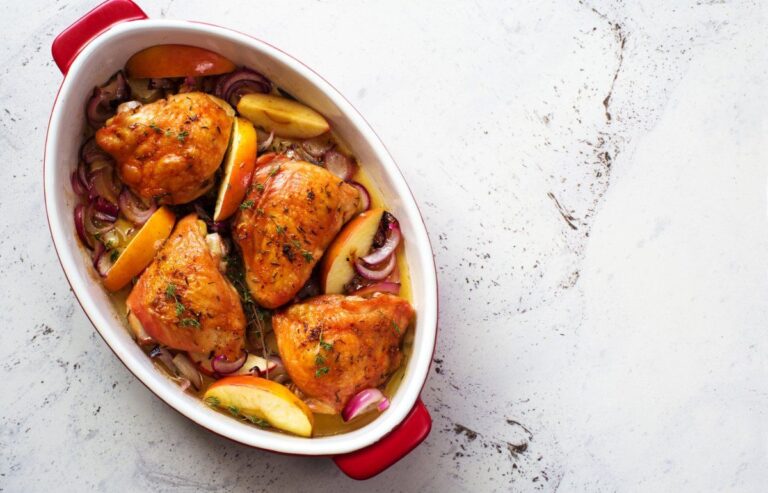 Hauts de cuisses de poulet au four avec pommes et oignons rouges.