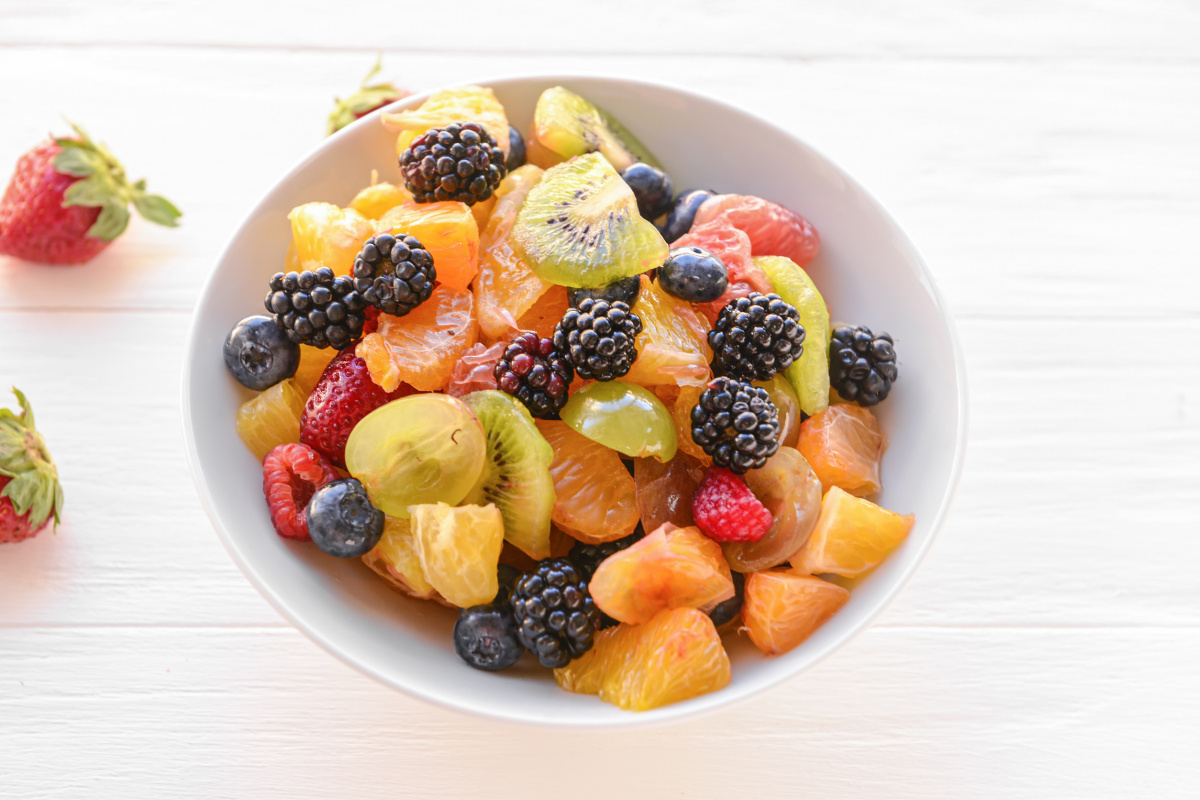 Salade de fruits frais color&eacute;e avec m&ucirc;res, oranges, kiwis et fruits rouges.
