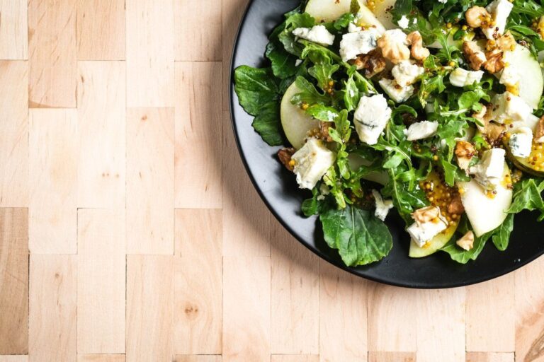 Salade fraîche de roquette avec poire, noix, et fromage bleu émietté.