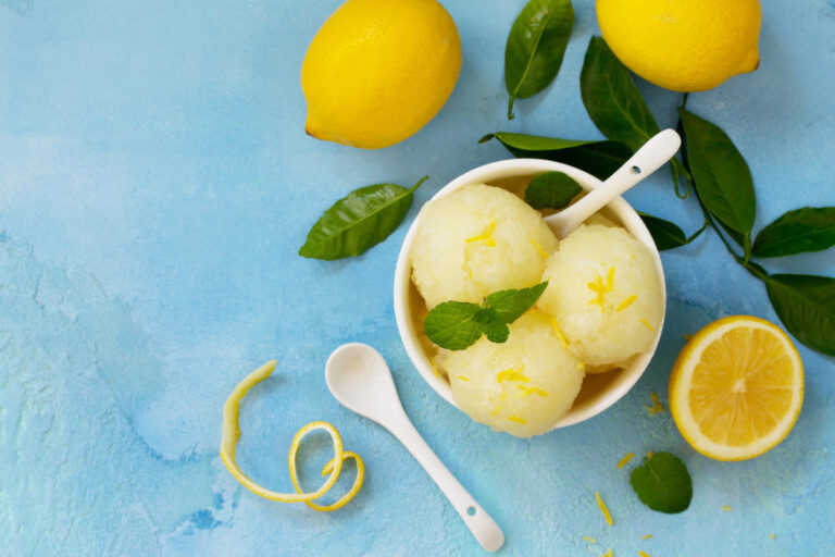 Boules de sorbet au citron maison garnies de zestes.