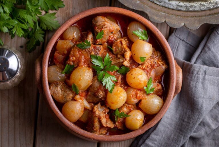 Stifado de bœuf grec mijoté en sauce tomate avec petits oignons et persil.