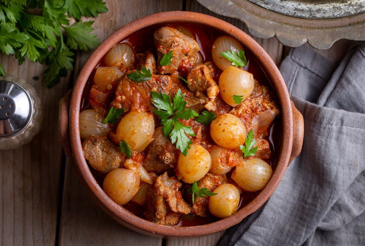 Stifado de b&oelig;uf grec mijot&eacute; en sauce tomate avec petits oignons et persil.