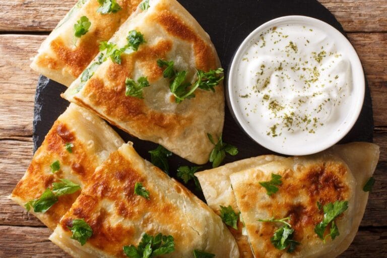Bolani, pain plat afghan farci aux herbes, servi avec une sauce au yaourt.