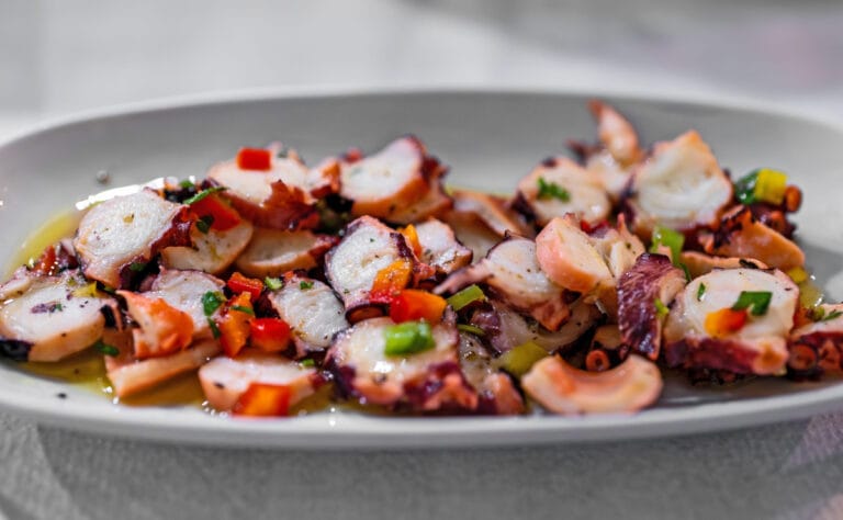 Carpaccio de poulpe avec poivrons, persil et huile d'olive.