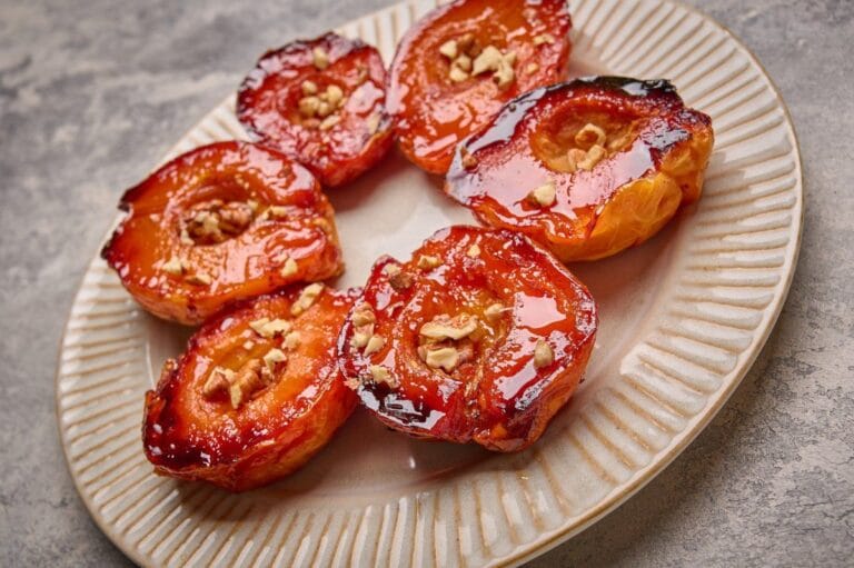 Demi-coings rôtis au four, glacés au miel et garnis de morceaux de noix.