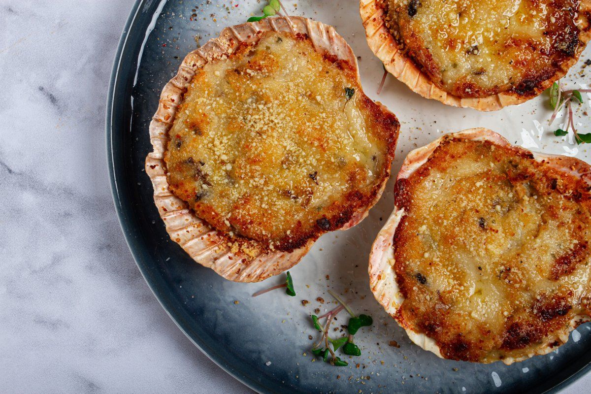 Trois coquilles Saint-Jacques farcies et gratin&eacute;es &agrave; la chapelure.