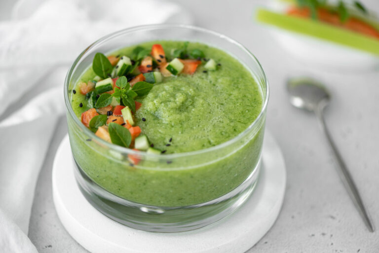 Gaspacho de concombre servi avec une garniture de légumes frais et herbes aromatiques.