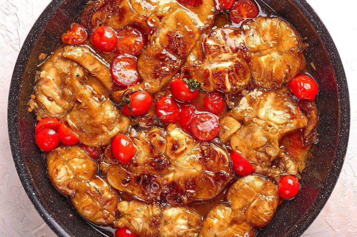 Darnes de poisson mijot&eacute;es dans une sauce aux tomates cerises et poivrons rouges.