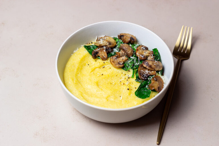 Polenta accompagnée de champignons sautés, d'épinards frais et de copeaux de parmesan.