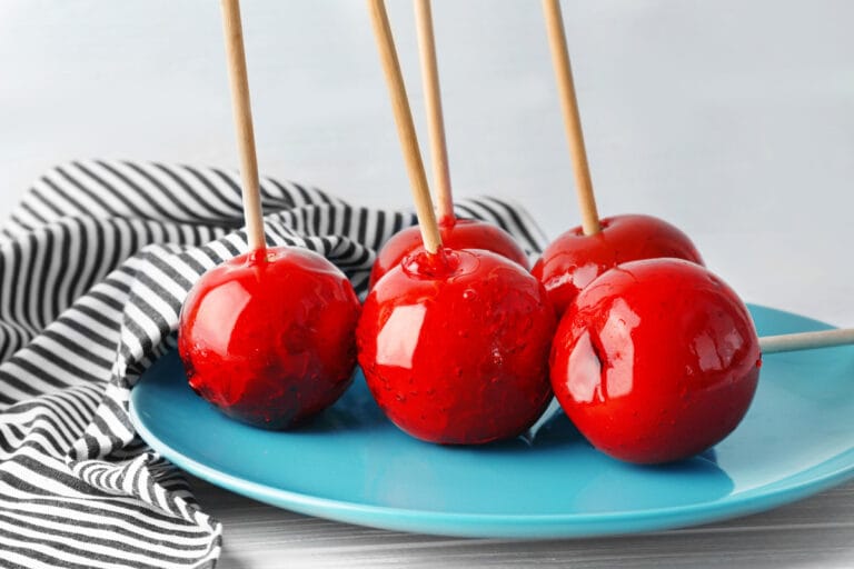 Pommes d'amour rouges et brillantes sur des bâtonnets en bois.