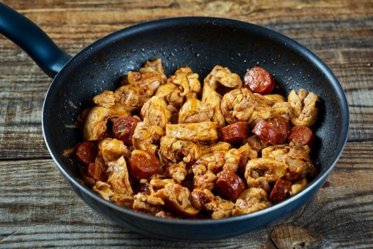 Morceaux de poulet et rondelles de chorizo cuits à la poêle.