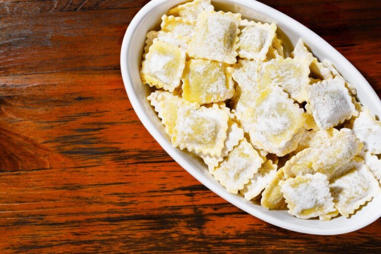 Raviolis carrés au bœuf faits maison, crus saupoudrés de farine.