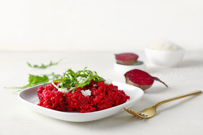 Risotto rouge à la betterave, garni de roquette fraîche et de parmesan émietté.